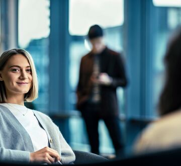 Ei kvinne med kort blondt hår på campus